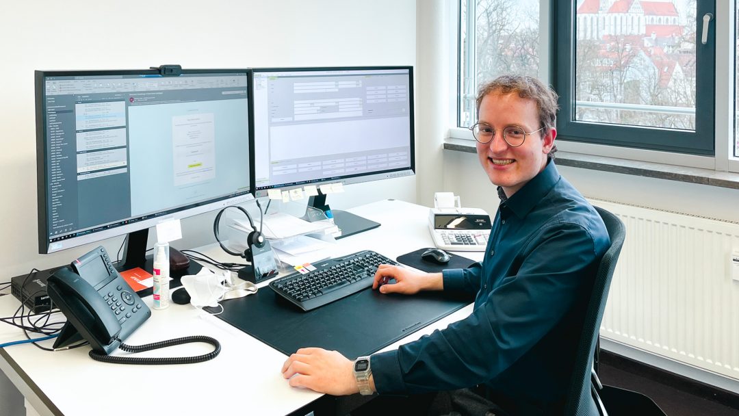 Simon an seinem modernen Arbeitsplatz in der Kanzlei SWMP in Augsburg Bildunterschrift: Vom Azubi zum Steuerfachangestellten und weiter zum Steuerberater – mit SWMP ist das möglich.